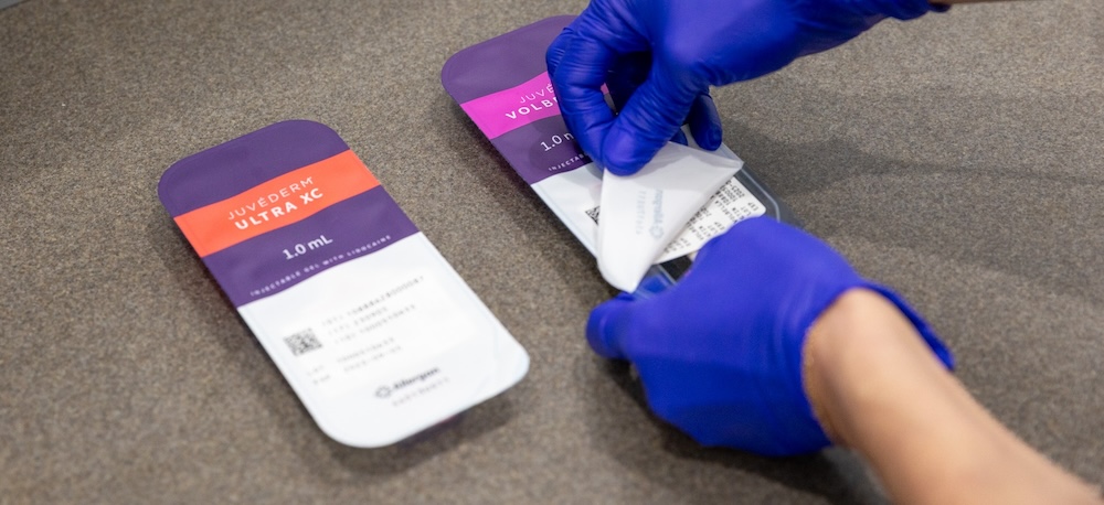 Professional wearing blue gloves opens packaged products for Botox and Fillers Near The Villages