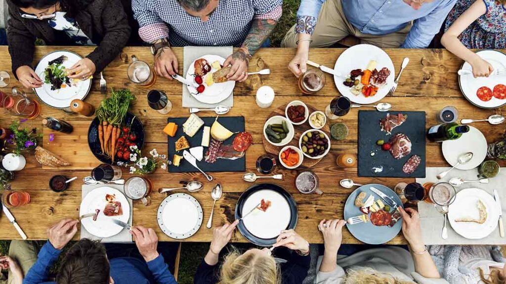 People gathered around table with healthy food spread
